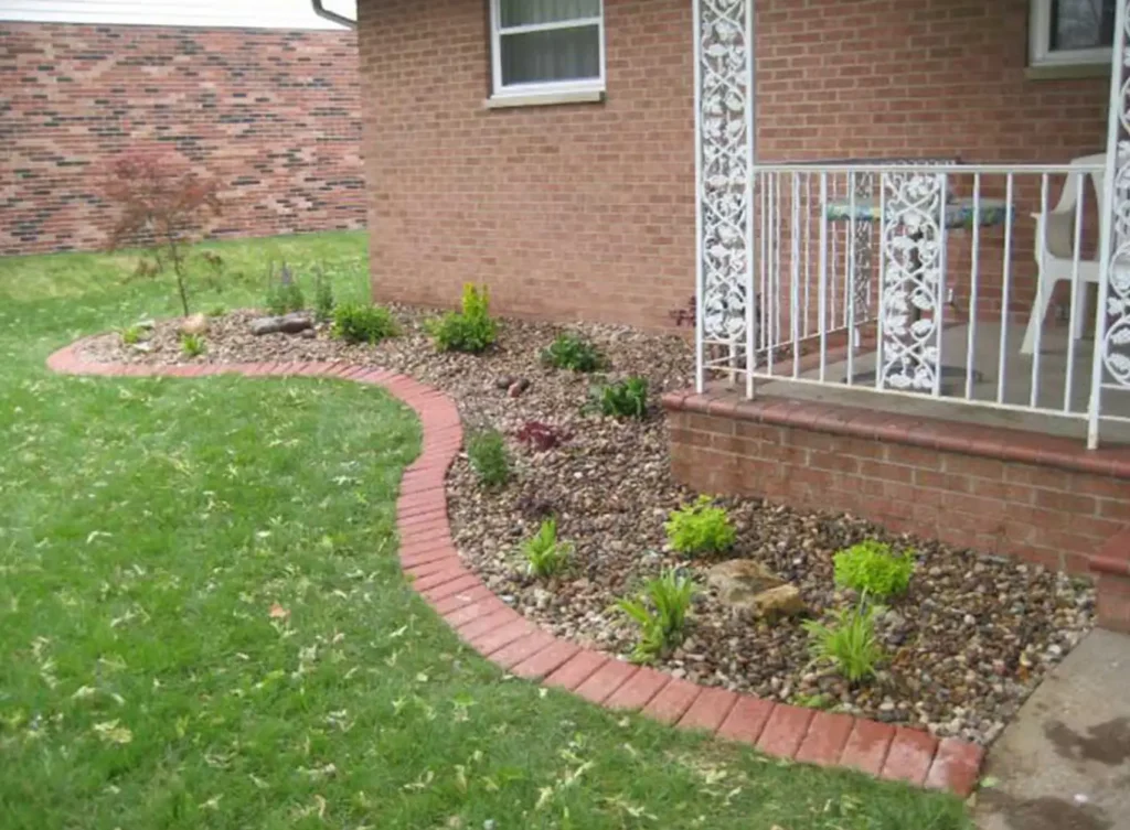 Element Turf & Outdoor Solutions - New Iowa River Rock installed in mulch bed at Alton, IL home.